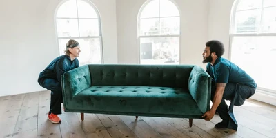 two men carrying a couch