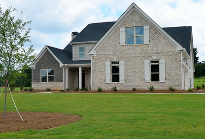 Stone home with white shutters and large lawn