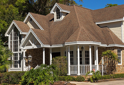 Stone home with white trim and tan roof
