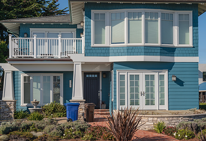 Blue and white single family home with brick pathway