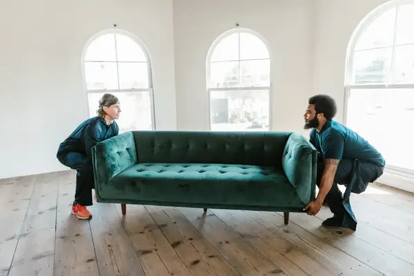 two men carrying a couch