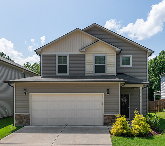 Tan and white 2 story home with white garage door