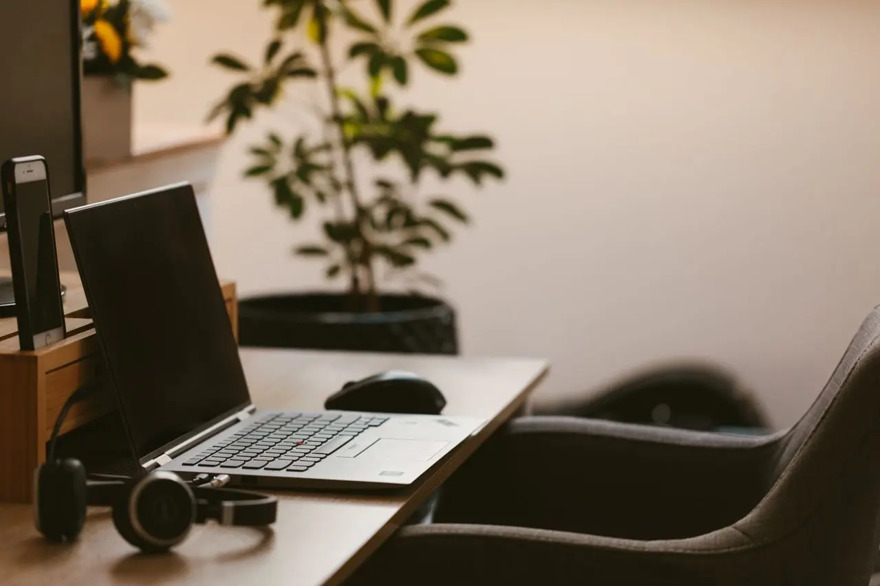 desk with laptop, headphones and chair