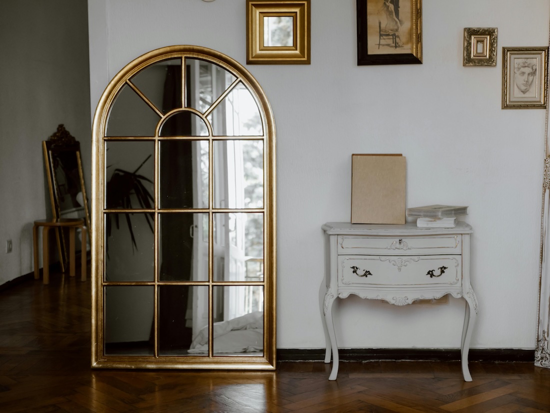 Wall with pictures and mirror with side table